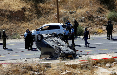 Israeli security forces gather at the scene following a shooting on an Israeli car near the West Bank city of Hebron July 1, 2016. REUTERS/Mussa Qawasma/File Photo