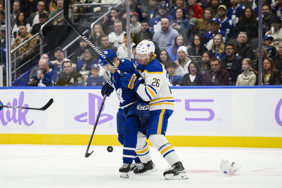 Buffalo Sabres defenseman Rasmus Dahlin (26) and Toronto Maple Leafs right wing Pontus Holmberg (29) fight for position during the second period of an NHL hockey game Saturday, Nov. 4, 2023, in Toronto. (Christopher Katsarov/The Canadian Press via AP)