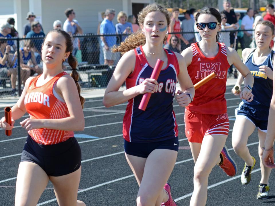 The 4x800 meter relay race started things off on the track during the annual Ram Scram in Harbor Springs, with (from left) Harbor's Juniper Rodham, Boyne City's Delaney Little and East Jordan's Lillian Curtis making a turn in the race.