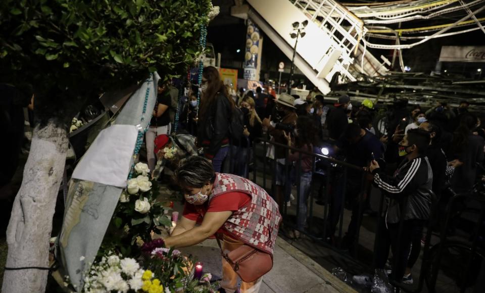 A woman places flowers at a makeshift altar for the people who died in Monday's subway collapse