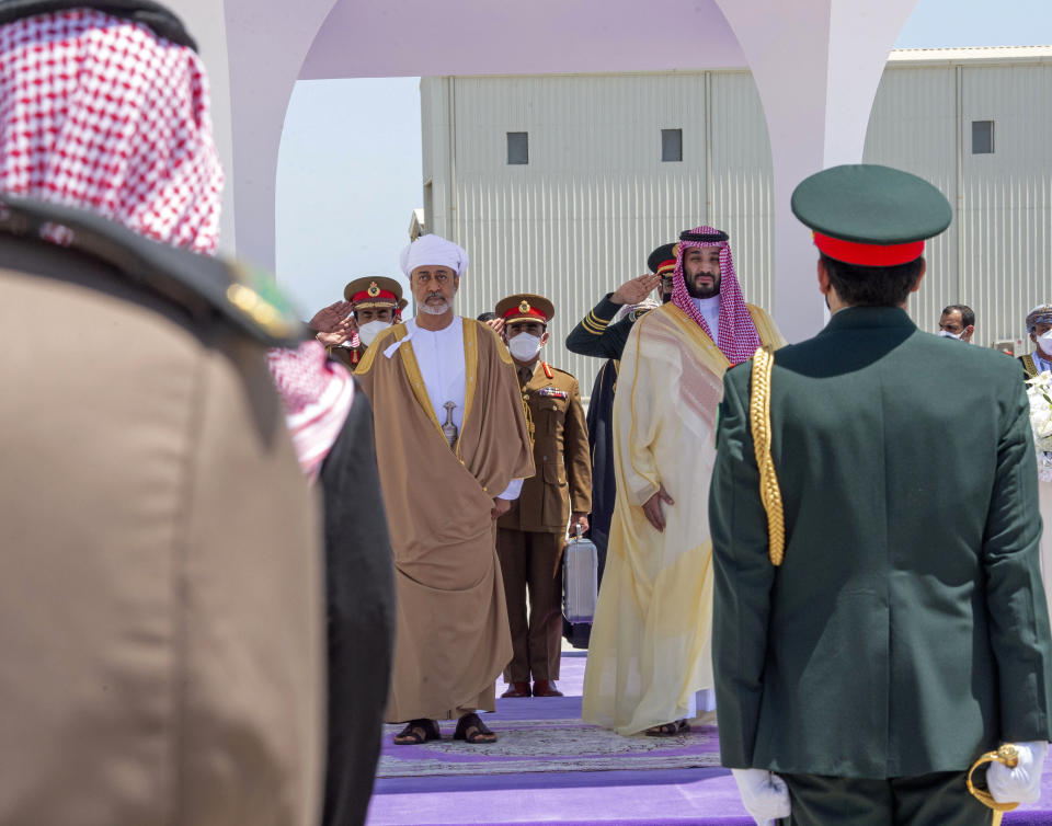 In this photo released by Saudi Royal Palace, Saudi Crown Prince Mohammed bin Salman, center right, and Omani Sultan Haitham bin Tariq, center left, review an honor guard during the welcoming ceremony at Neom Bay Airport, in the Tabuk Province of northwestern Saudi Arabia, Sunday, July 11, 2021. Sultan Haitham started the first visit by an Omani ruler in years against the backdrop of renewed diplomatic efforts to end the war in Yemen and the sultanate’s worsening economic woes. (Bandar Aljaloud/Saudi Royal Palace via AP)