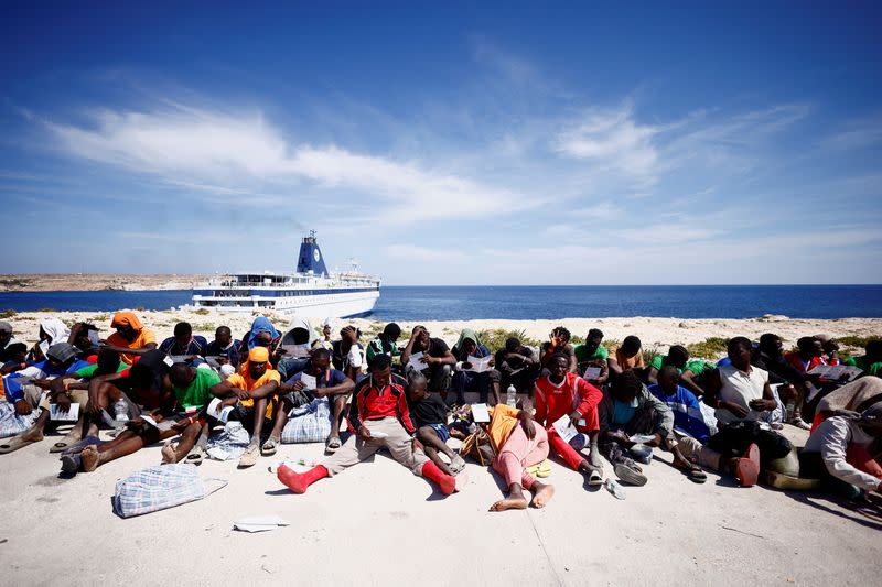 Foto del jueves de migrantes esperando cerca del puerto para ser trasladados a tierra e la isla de Lampedusa