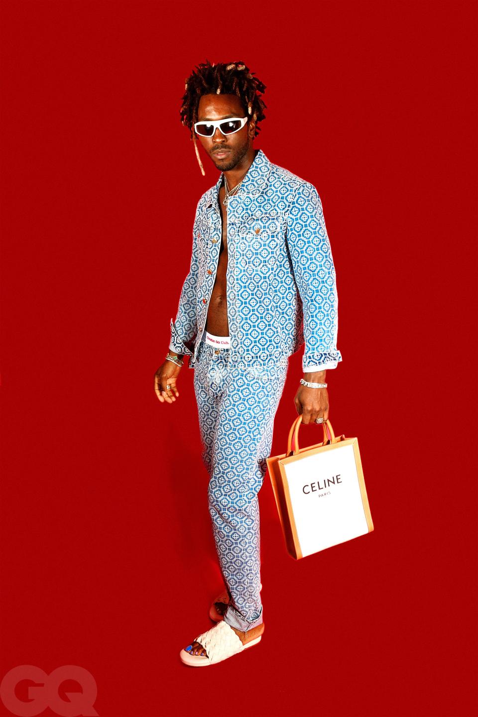 <cite class="credit">Jacket, and jeans (throughout), by Casablanca / Underwear (throughout), by Not a Cult / Slides, and sunglasses, by Bottega Veneta / Bag, by Celine by Hedi Slimane / Gold bracelet (right arm, throughout), by Van Cleef & Arpels / Silver bracelet (right arm, throughout), by Gucci / Link bracelet (right arm, throughout), by ByChari</cite>