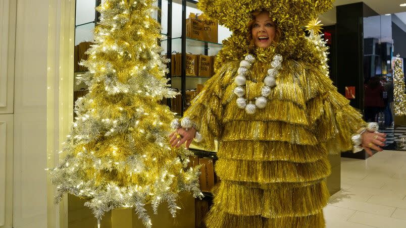 a genie played by melissa mccarthy wears a christmas tree outfit in a scene from genie