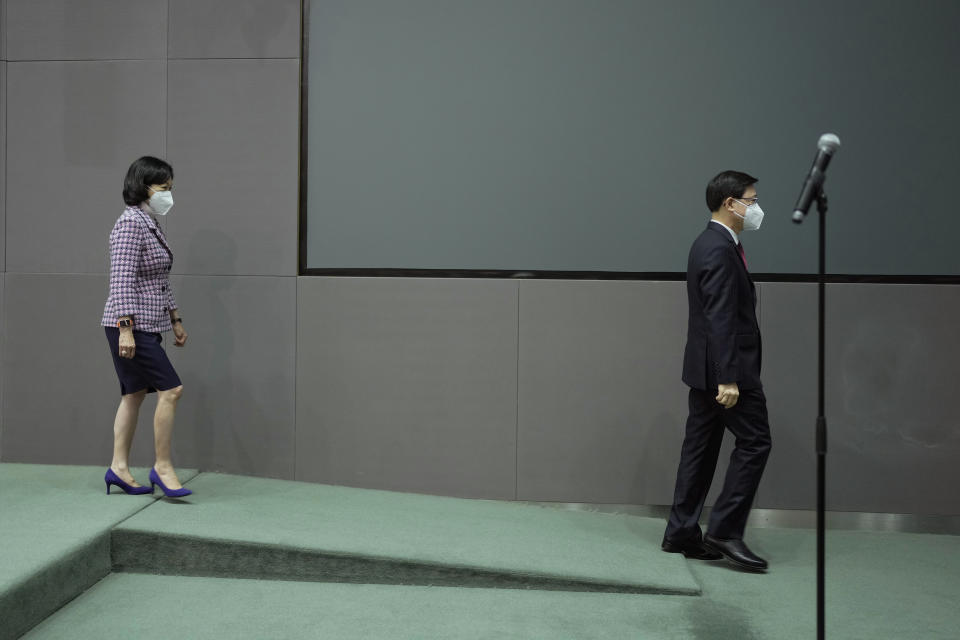 Hong Kong Chief Executive John Lee, right, and convener of the Executive Council Regina Ip leave a news conference in Hong Kong, Tuesday, July 5, 2022. Lee said Tuesday in his first news conference since taking the reins that he will work towards legislating easing restrictions for travelers, but that it must be balanced with limiting the spread of the coronavirus so as not to overwhelm the healthcare system. (AP Photo/Kin Cheung)