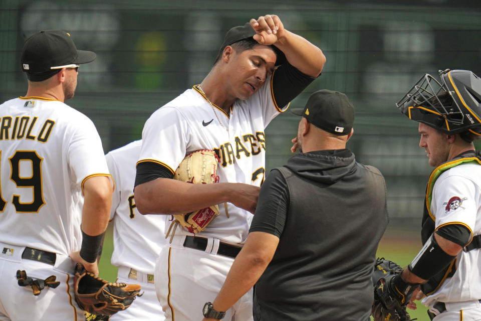 Pittsburgh Pirates starting pitcher Johan Oviedo, center, gets a visit from pitching coach Oscar Marin, second from right, during the second inning of a baseball game against the Milwaukee Brewers in Pittsburgh, Saturday, July 1, 2023. (AP Photo/Gene J. Puskar)