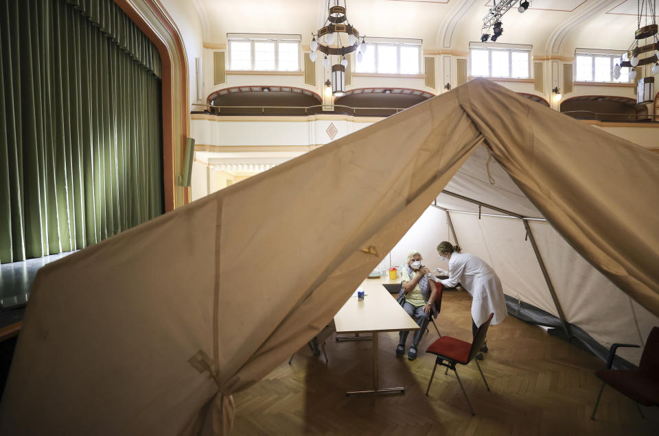 A woman receives dose of the Pfizer vaccine against the coronavirus and the Covid-19 disease in a tent at the mobile vaccination centre in the Great Linden Hall of the town hall in Markkleeberg, Germany, Monday, May 10, 2021. (Jan Woitas/dpa via AP)