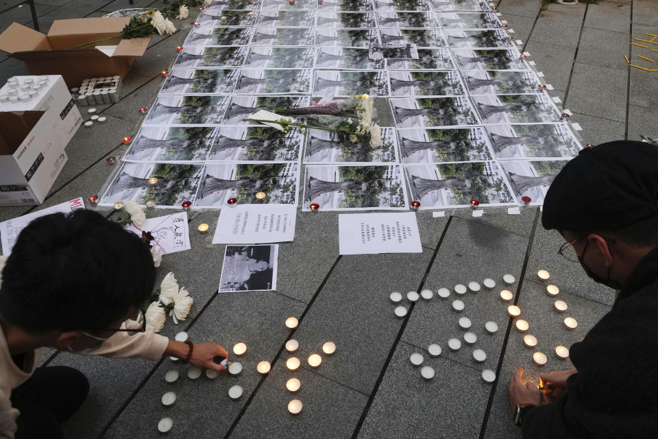 University students form Chinese words "Democracy" at the site after the "Goddess of Democracy" statue, a memorial for those killed in the 1989 Tiananmen crackdown, was removed from the University of Hong Kong Friday, Dec. 24, 2021. The Chinese University of Hong Kong early Friday morning took down the statue that was based on a figure created by art students and brought to the square shortly before the crackdown in which hundreds of people were killed. (AP Photo/Vincent Yu)