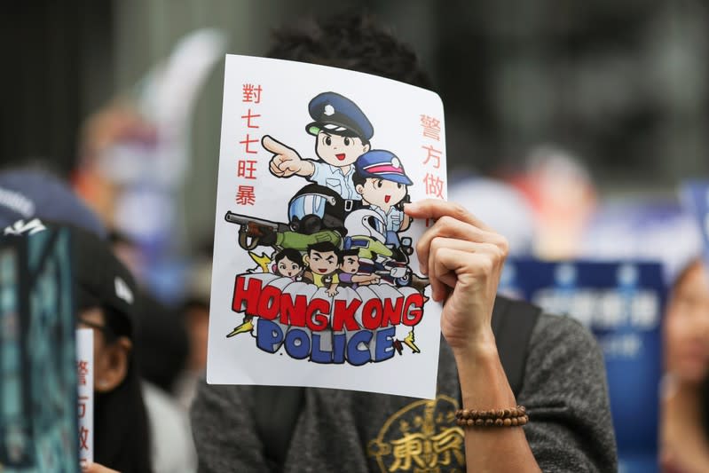 Un participante sostiene un cartel junto a otros durante una manifestación progubernamental para mostrar su apoyo a la policía y al Gobierno en el edificio del Consejo Legislativo (LegCo) en Hong Kong, China, el 16 de noviembre de 2019