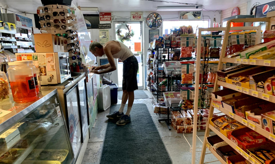 A customer pays for a purchase in the Palomino Deli and Mini Mart in Beatty, Ore., on Saturday. The store, the only one for miles in either direction on Highway 140, is a meeting place for locals. (Jim Seida / NBC News)