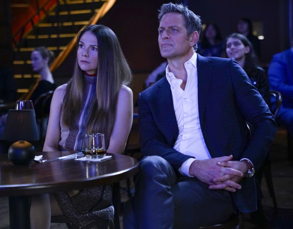 A woman and a man sit at a table in a theater