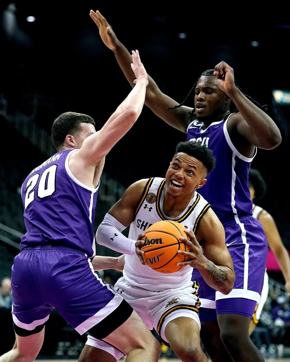Wichita State guard Xavier Bell, center, looks to shoot under pressure from Grand Canyon forwards Noah Baumann (20) and Yvan Ouedraogo, right, during the first half of an NCAA college basketball game in the Hall of Fame Classic, Monday, Nov. 21, 2022, in Kansas City, Mo. (AP Photo/Charlie Riedel)