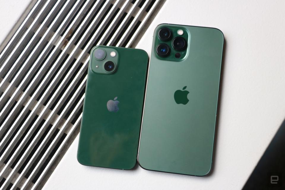 <p>A green iPhone 13 mini and an "Alpine green" iPhone 13 Pro Max on top of a surface with vents in the background.</p>
