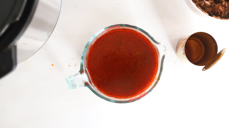 enchilada sauce and broth in a measuring cup