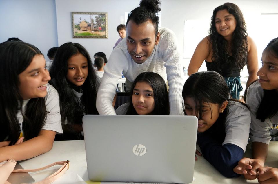 Musician and Syracuse University student Rufus Sivaroshan, center, teaches children doing audio engineering training at Step Ahead Tech, a a free, volunteer-run summer camp for children of immigrants that is focused on STEM subjects and soft skills that will prepare them for the job market.