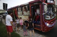 Bus driver Edilson, 45, also known as "Fumassa", greets children as he wears a Santa Claus outfit inside an urban bus decorated with Christmas motives in Santo Andre, outskirts Sao Paulo December 10, 2013. Fumassa dresses as Santa Claus every year while driving his bus. Picture taken December 10. REUTERS/Nacho Doce (BRAZIL - Tags: SOCIETY TRANSPORT)