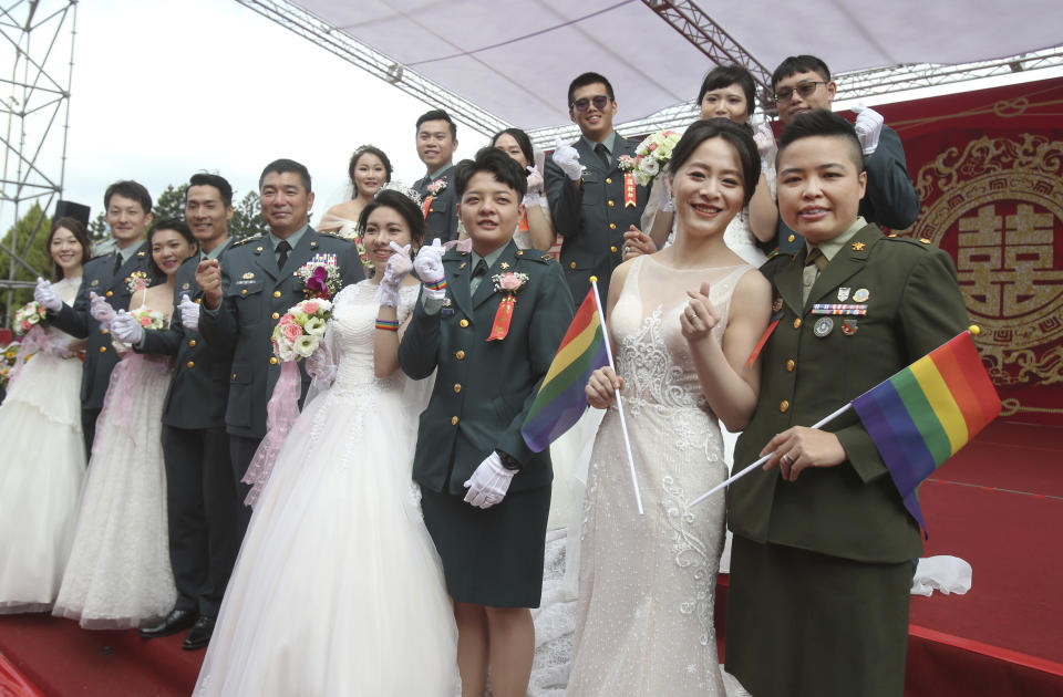 Two lesbian couples, from right to left, Yi Wang and Yumi Meng, Chen Ying-hsuan and Li Li-chen pose for a photo during a military mass weddings ceremony in Taoyuan city, northern Taiwan, Friday, Oct. 30, 2020. The two lesbian couples tied the knot in a mass ceremony held by Taiwan's military on Friday in a historic step for the island. Taiwan is the only place in Asia to have legalized gay marriage, passing legislation in this regard in May 2019.(AP Photo/Chiang Ying-ying)