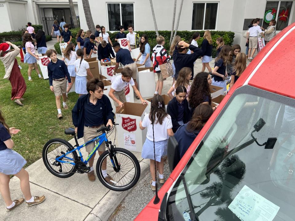 Rosarian Academy students pack Salvation Army of Palm Beach County vans with the donations collected during the school's Christmas drive.