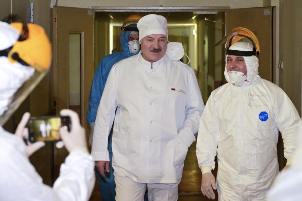 FILE In this file pool photo taken on Friday, Nov. 27, 2020, Belarusian President Alexander Lukashenko, center, listens to medic official as he visits the hospital for coronavirus patients in Minsk, Belarus. A wave of COVID-19 has spread through Belarusian jails packed with people imprisoned for taking part in four months of protests against the nation’s authoritarian president. Activists, who tested positive after being released, describe massively overcrowded cells and the lack of basic amenities, and some even allege that the authorities have deliberately spread contagion among political prisoners. (Andrei Stasevich/BelTA Pool Photo via AP, File)