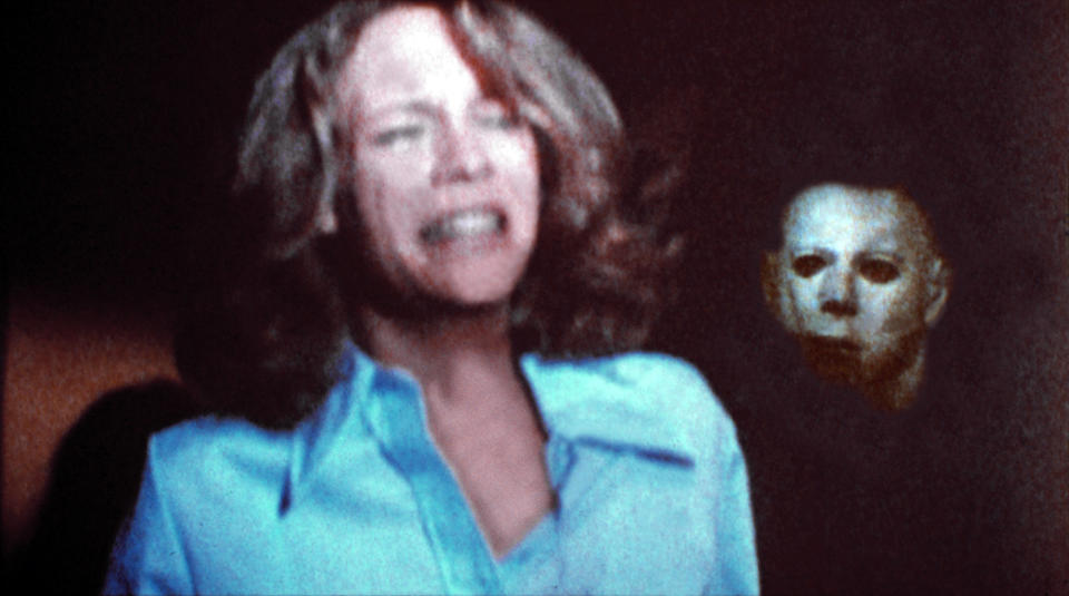 Jamie Lee Curtis crying with a masked Nick Castle in the background