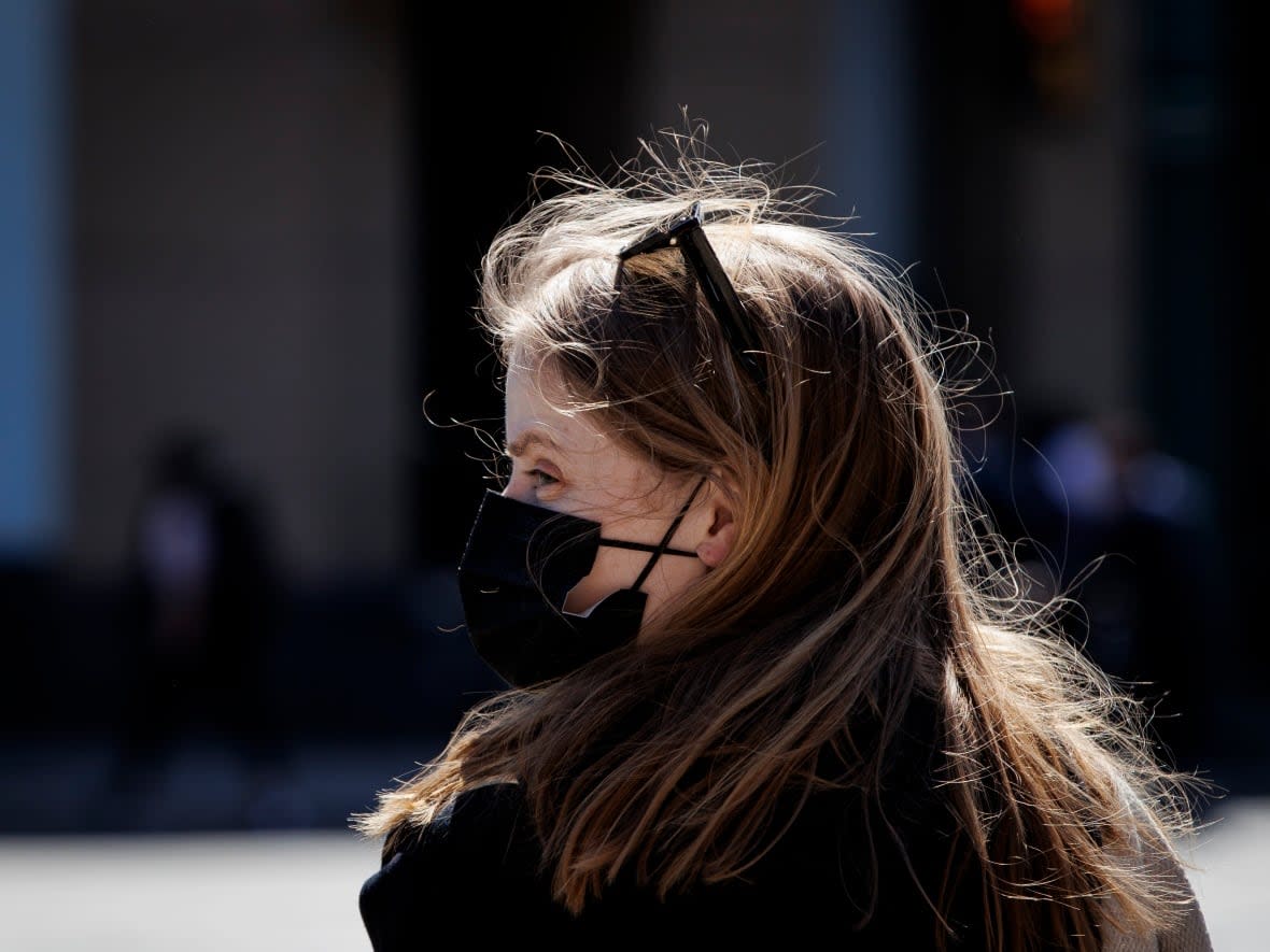 A woman wearing a mask is pictured in downtown Toronto on April 12, 2022. Cases of COVID-19 are increasing during a sixth wave of the pandemic in Ontario. (Evan Mitsui/CBC - image credit)