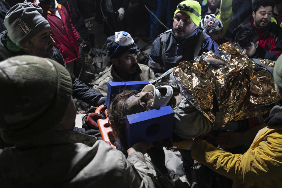 Rescue teams pull out a person from the debris of collapsed buildings in Hatay, southern Turkey, Thursday, Feb. 9, 2023. Emergency crews made a series of dramatic rescues in Turkey on Friday, pulling several people, some almost unscathed, from the rubble, four days after a catastrophic earthquake killed more than 20,000. (AP Photo/Can Ozer)