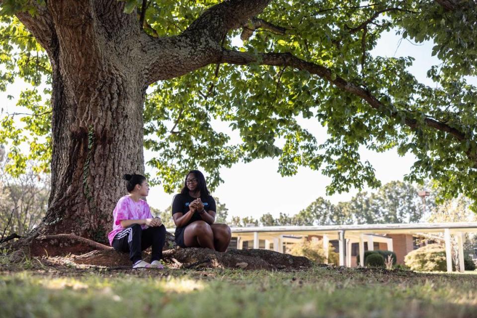 Students sit under a tree in the quad that students want to keep at Harding University High School in Charlotte, N.C., on Wednesday, October 5, 2023. Khadejeh Nikouyeh/Knikouyeh@charlotteobserver.com