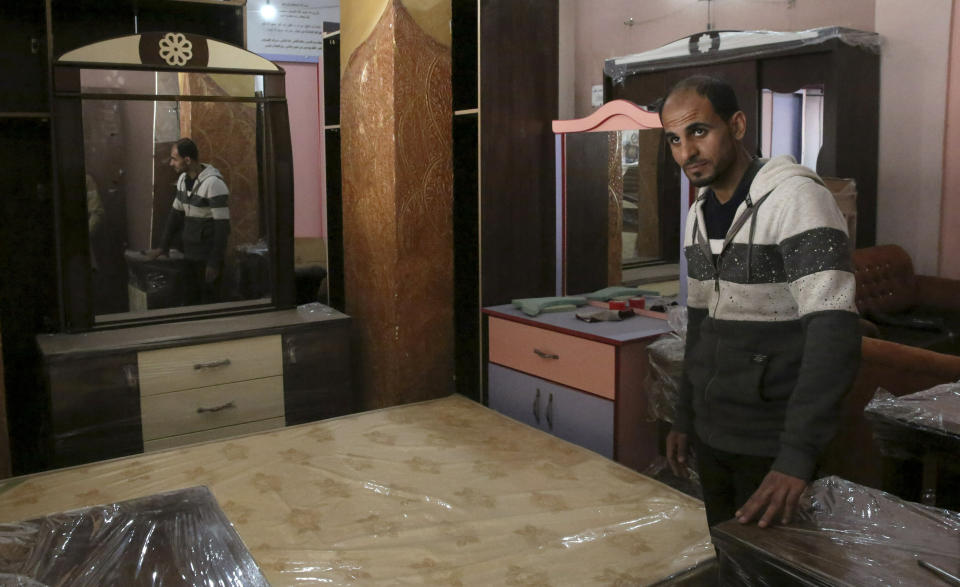 In this April 21, 2019 photo, Palestinian groom Yehiya Taleb, chooses his wedding furniture before his wedding, at a furniture workshop in Gaza City. Hundreds of young men in the Gaza Strip have turned to a small industry of lenders to help them pay for their weddings. Taleb got a job working as a waiter at a cafe earning about $180 a month, but that amount was not enough to cover wedding expenses so he took out a $2,000 package through the Farha Project, one of the wedding financing companies. (AP Photo/Adel Hana)