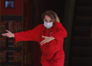 A staff member of a toy store wears a face mask as she invites customers to enter the store, in London, Tuesday, Sept. 22, 2020. British Prime Minister Boris Johnson has slammed the brakes on the country's return to offices, saying people should work from home if possible to help slow the spread of the coronavirus. Johnson on Tuesday announced a package of new restrictions, including a requirement for pubs, restaurants and other hospitality venues in England to close between 10 p.m. and 5 a.m. (AP Photo/Frank Augstein)