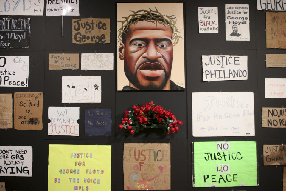 Signs and a portrait are displayed at a new exhibit, "Twin Flames: The George Floyd Uprising from Minneapolis to Phoenix," at Arizona State University Art Museum, in Tempe, Arizona on Friday, Feb. 2, 2024. For months after George Floyd was killed by police in May 2020, people from around the world traveled to the site of his murder in Minneapolis and left signs, paintings and poems to memorialize the man whose death reignited a movement against systemic racism. Now hundreds of those artifacts are being displayed at an exhibit at the Arizona State University Art Museum. (AP Photo/Cheyanne Mumphrey)