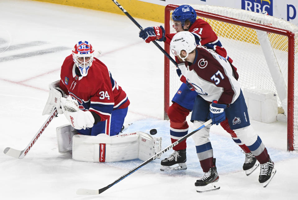 Montreal Canadiens goaltender Jake Allen (34) is scored against by Colorado Avalanche's Logan O'Connor (not shown) as Canadiens' Kaiden Guhle (21) and Avalanche's J.T. Compher (37) look on during first-period NHL hockey game action in Montreal, Monday, March 13, 2023. (Graham Hughes/The Canadian Press via AP)