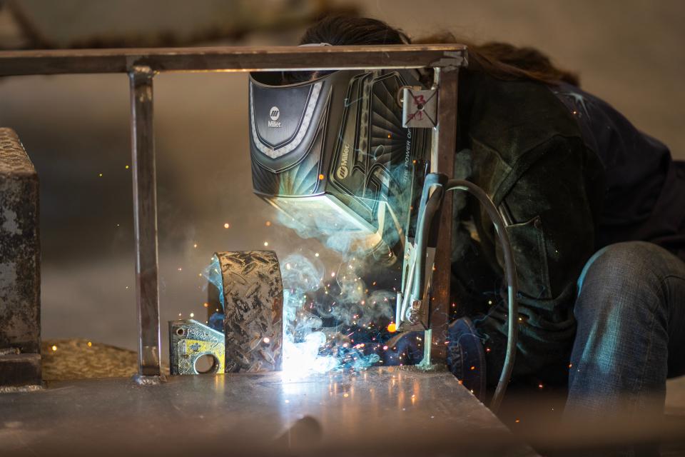 Julie Gonzalez, a student in the welding and fabrication program at Rancho Cielo, secures brake lights to a trailer.