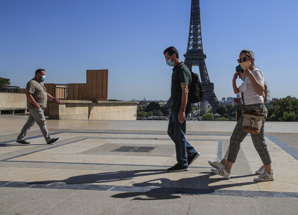 People wearing protective face masks as precaution against the conoravirus walk at Tocadero plaza near Eiffel Tower in Paris, Monday, Sept. 14, 2020. France sees a substantial increase of Covid-19 cases. (AP Photo/Michel Euler)