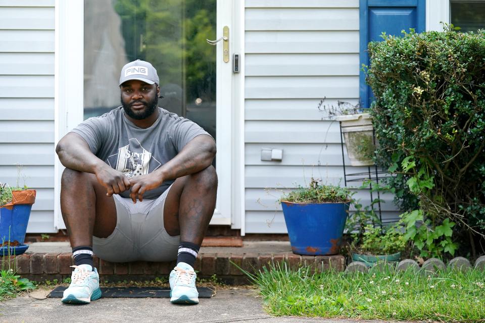 Cincinnati Bengals defensive tackle DJ Reader sits on the step for a portrait in front of the house he grew up in, Friday, June 16, 2023, in Greensboro, N.C. Reader was homeschooled by his dad, David Reader, from second until sixth grades.