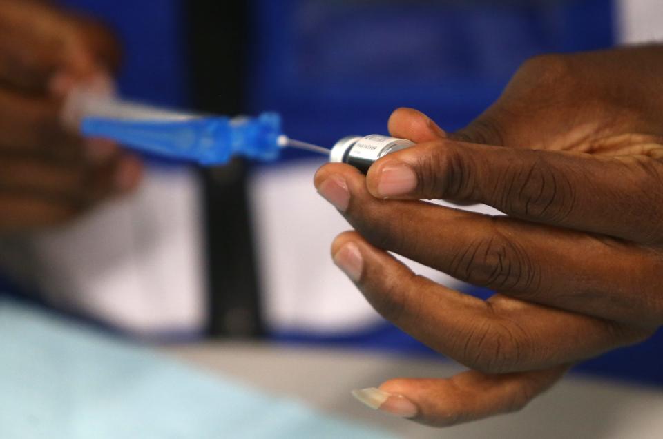 Abe Oluwasegun, an advanced practice registered nurse, readies a vaccine during a clinic in the West End of Louisville, Kentucky, at the Shawnee Arts & Cultural Center on Oct. 14.