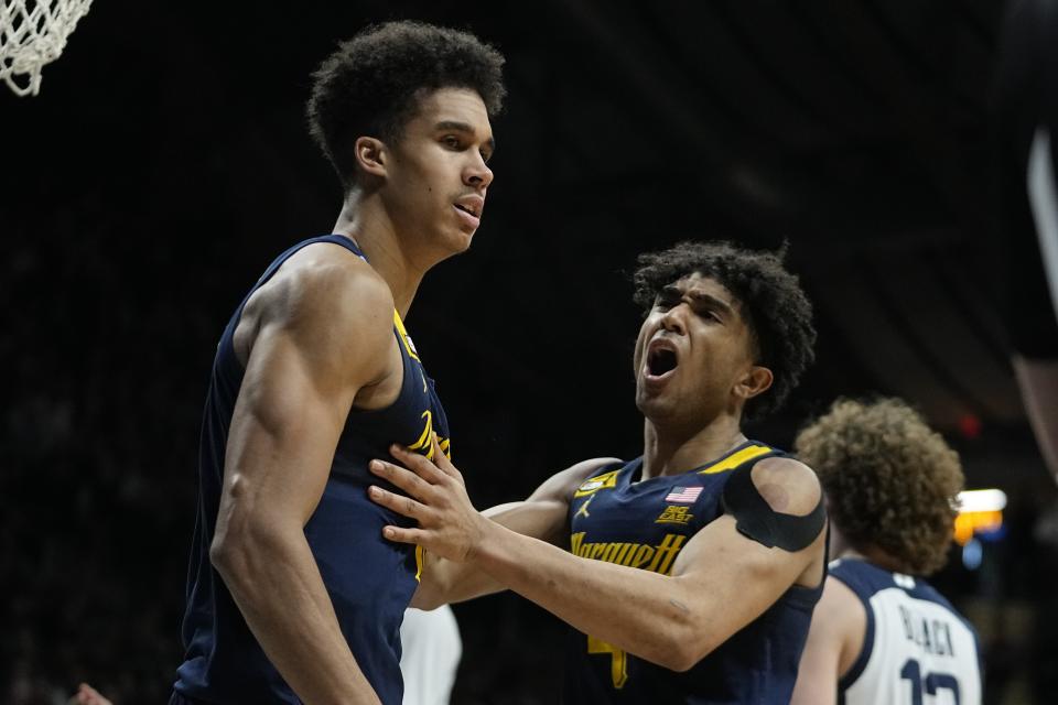 Marquette's Oso Ighodaro, left, reacts with Stevie Mitchell after Ighodaro made a shot and was fouled during the second half of the team's NCAA college basketball game against Butler, Tuesday, Feb. 13, 2024, in Indianapolis. (AP Photo/Darron Cummings)