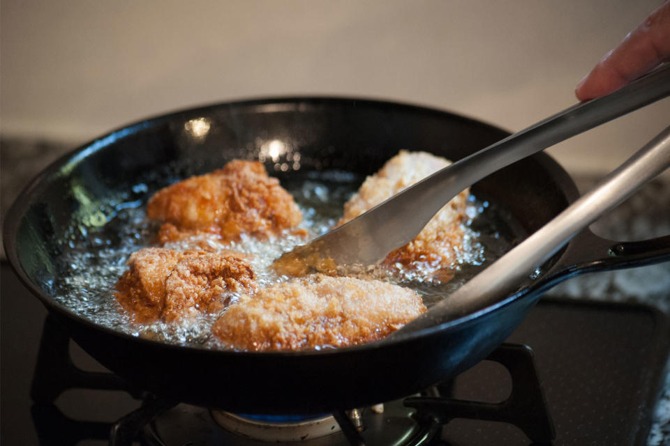 A person making fried chicken.