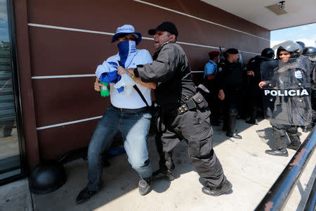 Riot police try to detain a protester during a march called "United for freedom" against Nicaraguan President Daniel Ortega in Managua, Nicaragua October 14, 2018. REUTERS/Oswaldo Rivas