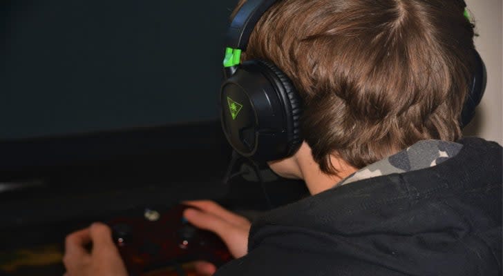 Image of a gamer with a headset facing a screen