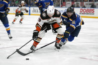 Anaheim Ducks' Troy Terry (19) and St. Louis Blues' Matthew Kessel (51) battle for a loose puck during the third period of an NHL hockey game Sunday, March 17, 2024, in St. Louis. (AP Photo/Jeff Roberson)