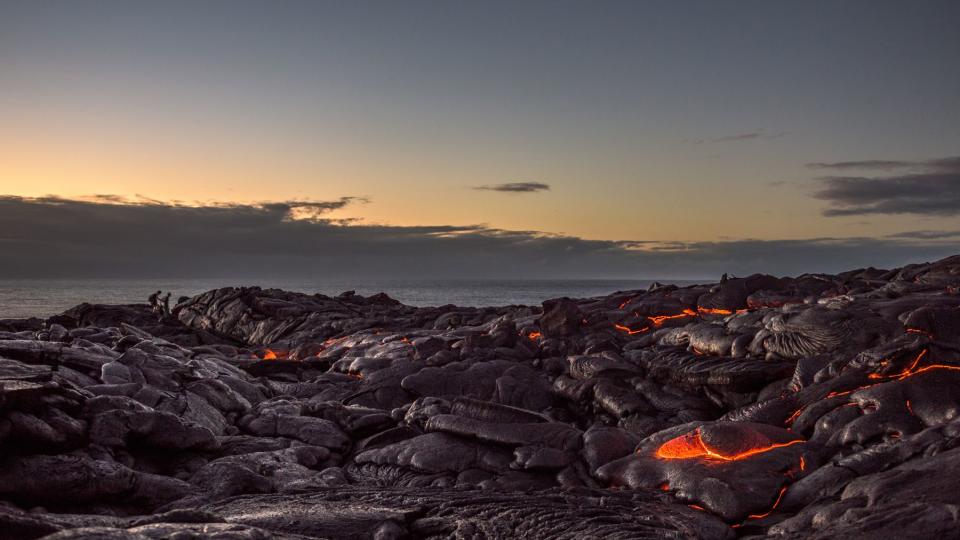 Walking on a field of lava on the Pacific coast near Kalapana on the Big Island of Hawaii at dawn.