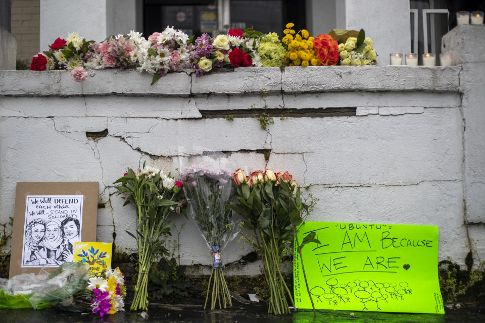 Flowers and signs are displayed at a makeshift memorial outside of the Gold Spa in Atlanta, Wednesday, March 17, 2021. Police in the Atlanta suburb of Gwinnett County say they've begun extra patrols in and around Asian businesses there following the shooting at three massage parlors in the area that killed eight, most of them women of Asian descent. (Alyssa Pointer/Atlanta Journal-Constitution via AP)