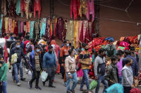 Indians, most of them, wearing face masks as a precautionary measure against the coronavirus crowd a Sunday market in Jammu, India, Sunday, Nov.22, 2020. (AP Photo/Channi Anand)