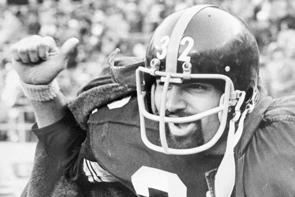 FILE - Pittsburgh Steelers running back Franco Harris gives the thumbs up sign as he runs off the field into the locker room following Pittsburgh's 27-3 victory over the Cincinnati Bengals, Dec. 16, 1974. Franco Harris, the Hall of Fame running back whose heads-up thinking authored “The Immaculate Reception,” considered the most iconic play in NFL history, died Wednesday, Dec. 21, 2022. He was 72. (AP Photo/GRG, File)