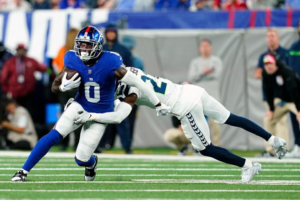 New York Giants wide receiver Parris Campbell (0) is tackled by Seattle Seahawks cornerback Devon Witherspoon (21) in the first half at MetLife Stadium on Monday, Oct. 2, 2023, in East Rutherford.