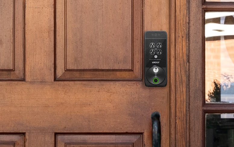 A black smart lock on a wooden door. 