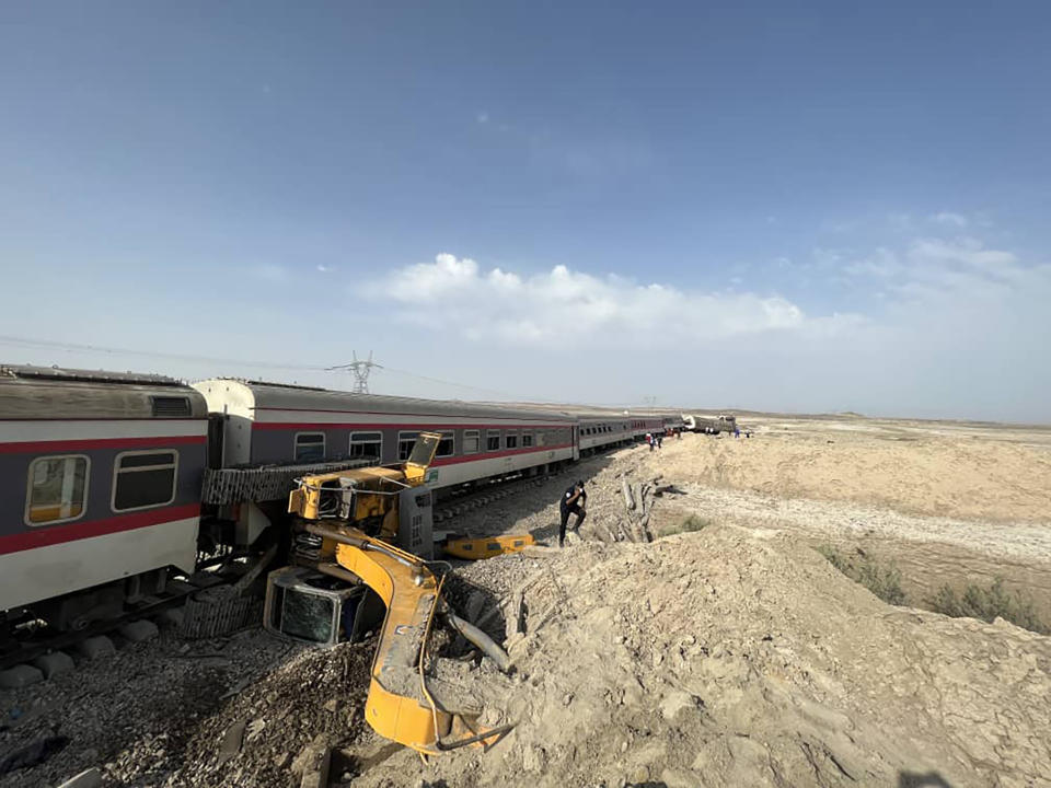 This photo provided by the Iranian Red Crescent Society, shows the scene where a passenger train partially derailed near the desert city of Tabas in eastern Iran, Wednesday, Iran, Wednesday, June 8, 2022. (Iranian Red Crescent Society via AP)