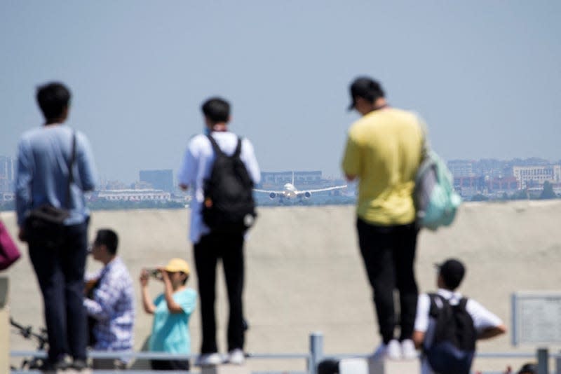 People take photos of the Comac C919 make its first commercial flight in Shanghai