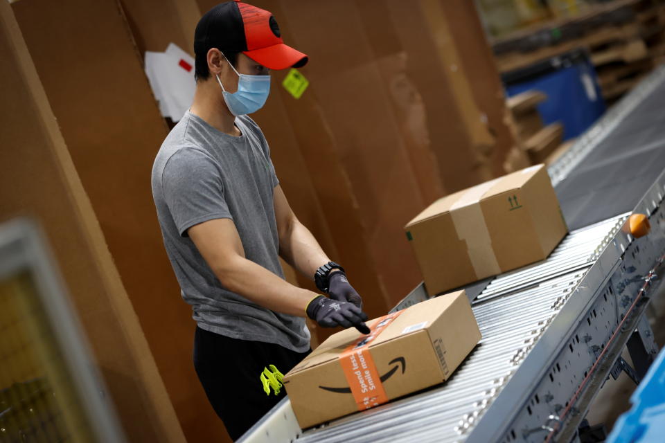 A worker moves boxes of goods to be scanned and sent to delivery trucks during operations at Amazon's Robbinsville fulfilment centre 