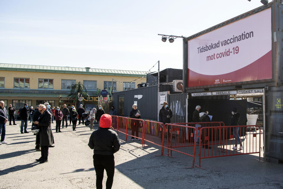 People wait in line to get vaccine against coronavirus, at a night club turned into a mass vaccination center in Stockholm, Sweden, Friday April 16, 2021. (Carl-Olof Zimmerman/TT News Agency via AP)